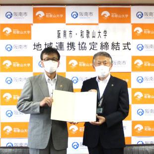 協定式にて和歌山大学の伊東学長と協定書を掲げる水野市長