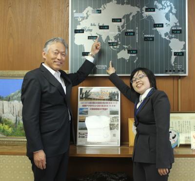 JICA青年協力隊としてヨルダンへ向かう田村彩子さんと世界地図を指す水野市長