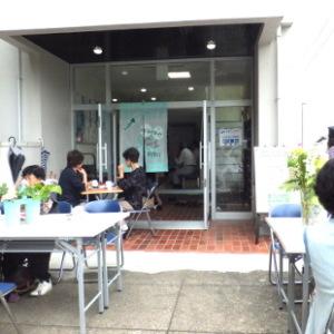 緑ヶ丘モーニングカフェが開催中の緑ヶ丘住民センター玄関前にも机といすが並び訪問者が軽食を取りながら談笑する様子