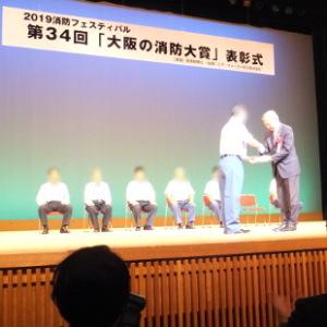 大阪の消防大賞表彰式にて受賞者へのプレゼンターを務める水野市長