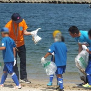 子どもたちと海岸清掃に励むFC大阪の吉澤会長と水野市長