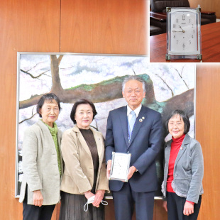 阪南市更生保護女性会の皆さんと記念品の置時計を手に記念撮影する水野市長