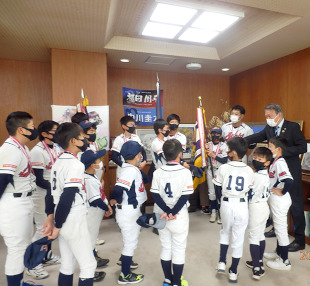 朝日少年野球団の選手たちに囲まれ質問に答える水野市長