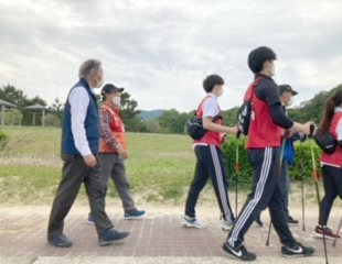 ビーチノルディックウォーク大阪の参加者と一緒に歩きながら声を掛ける水野市長