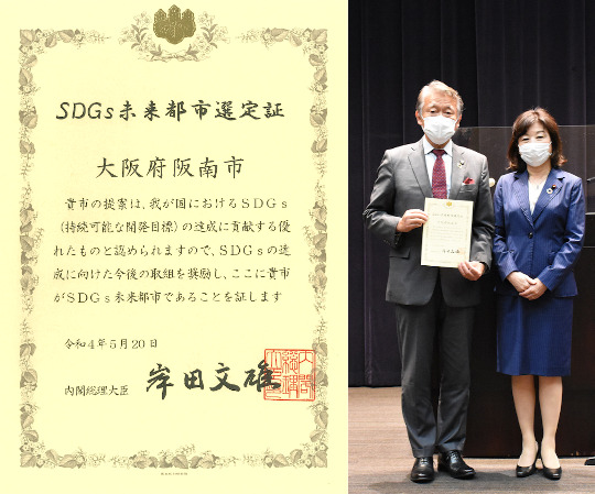 阪南市SDGs未来都市選定証と、選定証を手に野田大臣と記念撮影する水野市長