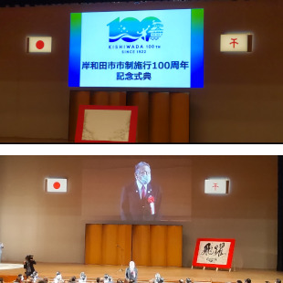 岸和田市市制施行100周年記念式典開式前の会場の様子と来賓として紹介されて挨拶をする水野市長