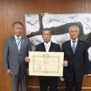 瑞宝単光章を受章された高松さんと北野消防団長とともに記念撮影する水野市長