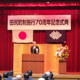 田尻町制施行70周年記念式典の壇上で栗山町長が挨拶されている様子