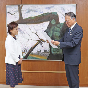 図書費の寄贈に対し国際ソロプチミスト大阪-りんくうの金田会長に感謝状を読み上げている水野市長