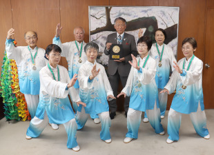 演舞衣装の南海太極拳クラブの7人の皆さんと記念撮影している水野市長