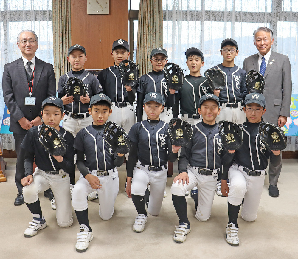 少年野球ワンワンスポーツクラブの子どもたちと橋本教育長と記念撮影する水野市長